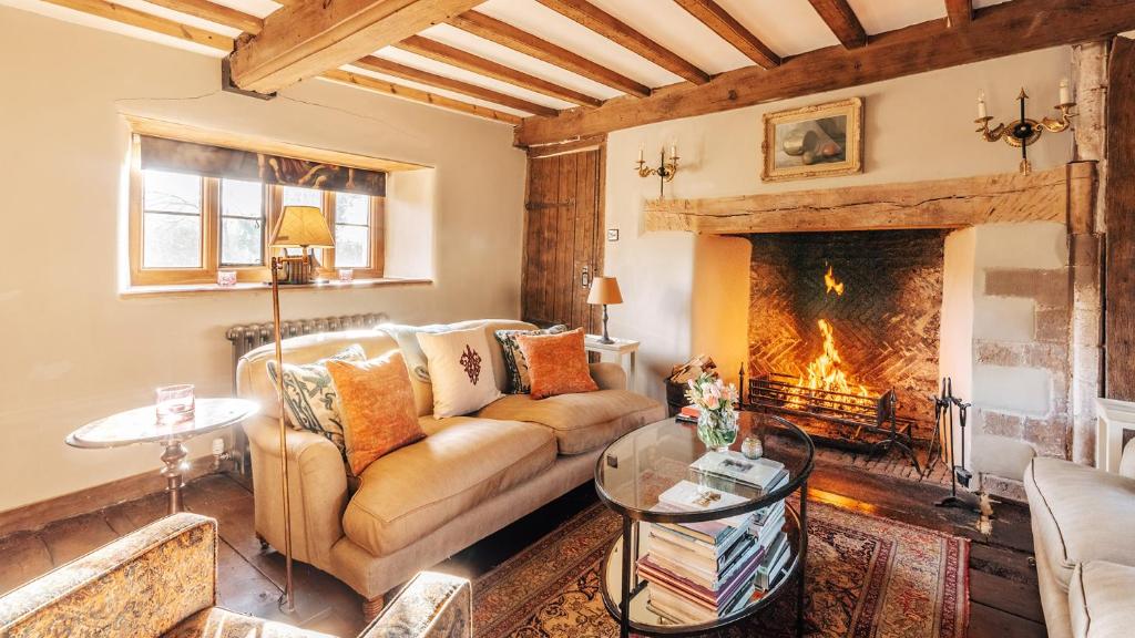 a living room with a couch and a fireplace at Beaufort Farmhouse in Grosmont