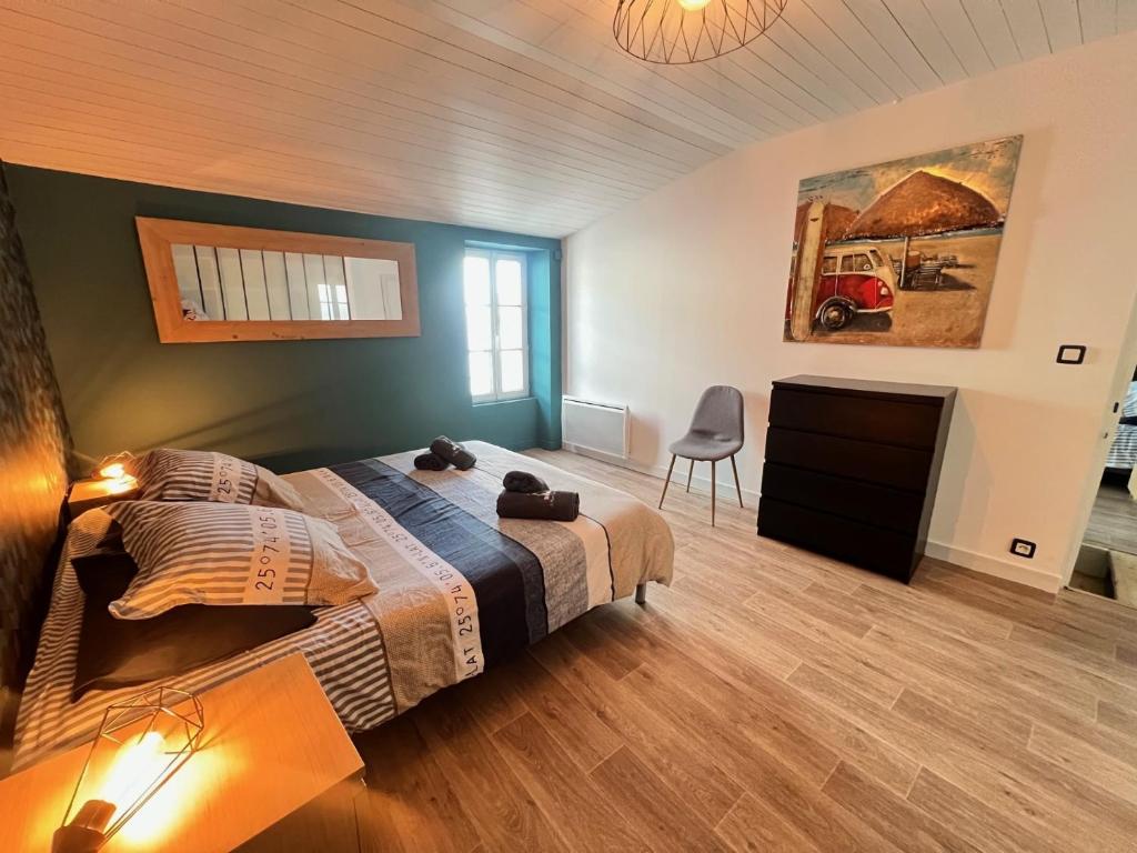 a bedroom with a large bed and a desk and a chair at Le Phare des Baleines in La Flotte