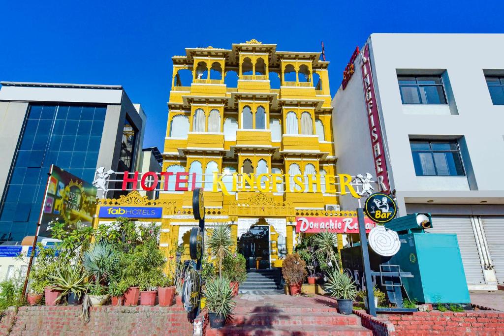 a yellow building with a sign in front of it at FabHotel Prime Kingfisher in Udaipur