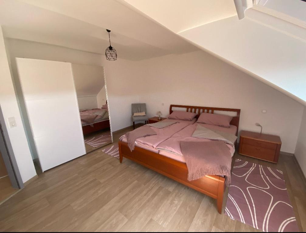 ein Schlafzimmer mit einem großen Bett im Dachgeschoss in der Unterkunft Ferienwohnung Am Rathausberg in Schiffweiler