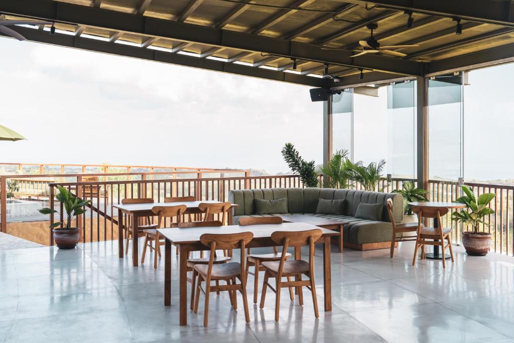 a patio with tables and chairs and a couch at Grün Resort Uluwatu in Uluwatu