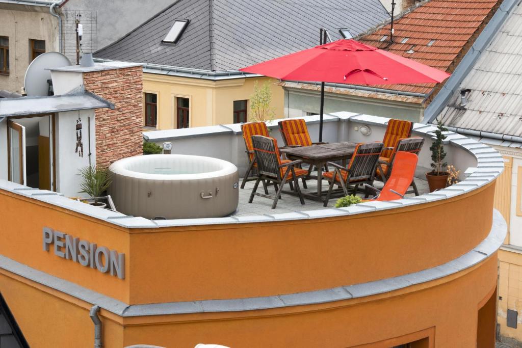 een balkon met een tafel en stoelen op een dak bij Pension u Lašanů in Třešť