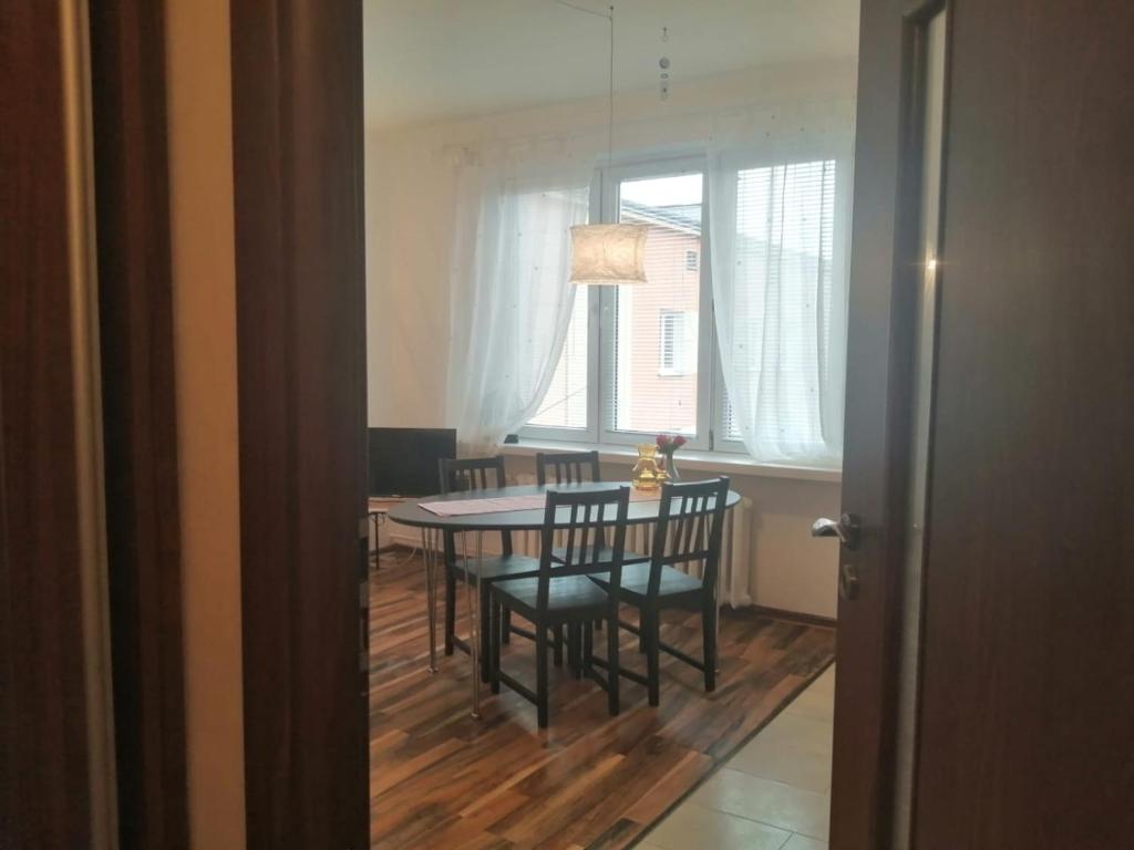 een eetkamer met een tafel en stoelen en een raam bij Parkowy Apartment in Bydgoszcz