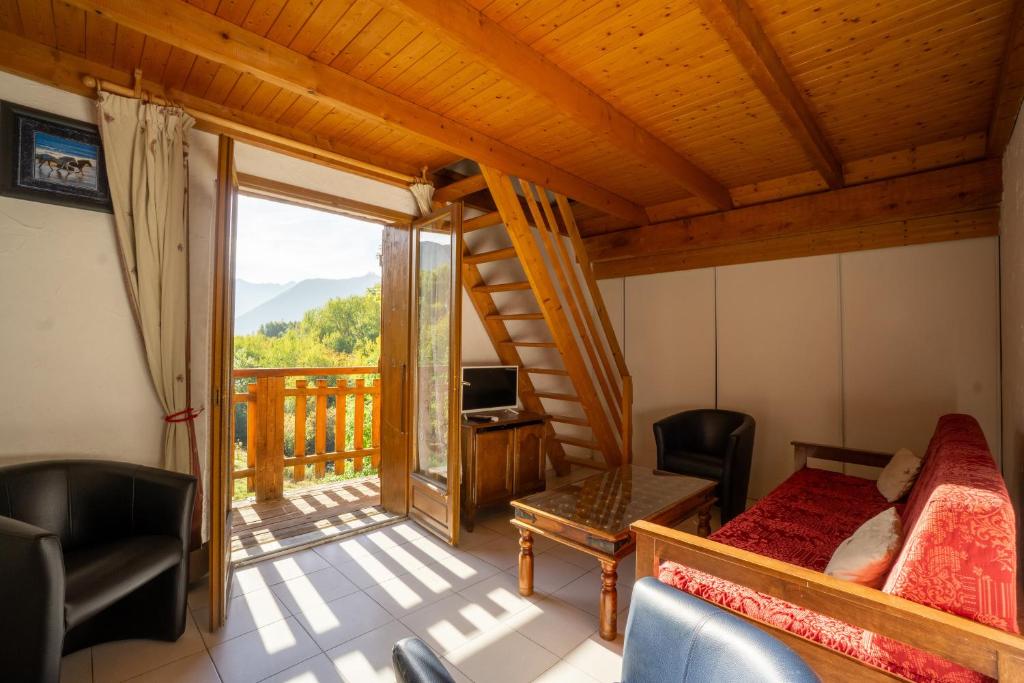 a room with a bed and a tv and a balcony at Appartement 10 in Saint-Sorlin-dʼArves
