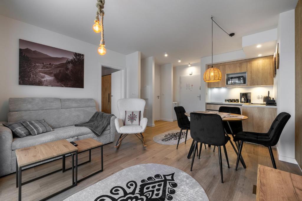 RentPlanet - Apartamenty Zakopiańskie في زاكوباني: غرفة معيشة مع أريكة وطاولة