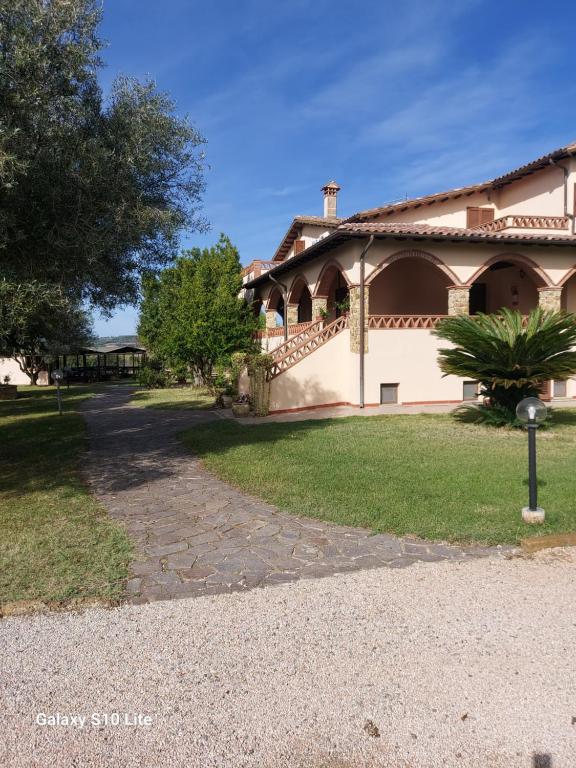 una casa con un camino que conduce a un patio en Agriturismo La Verde Rosa, en Pescia Romana