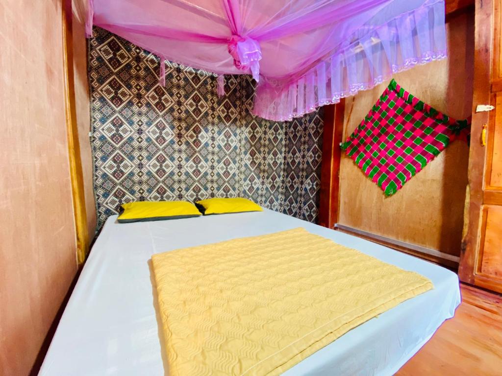 a bed with yellow pillows and a purple canopy at Du Già Coffee View Homestay in Làng Cac