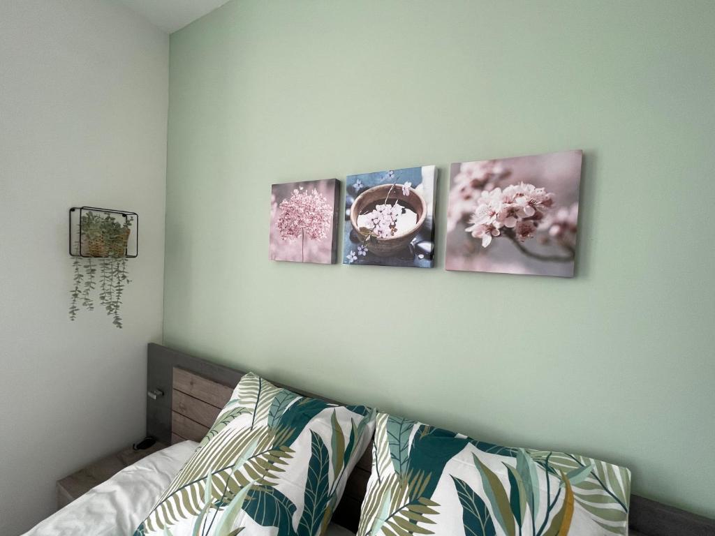 three pictures hanging on a wall above a bed at Studio de la Poterie in Vermenton