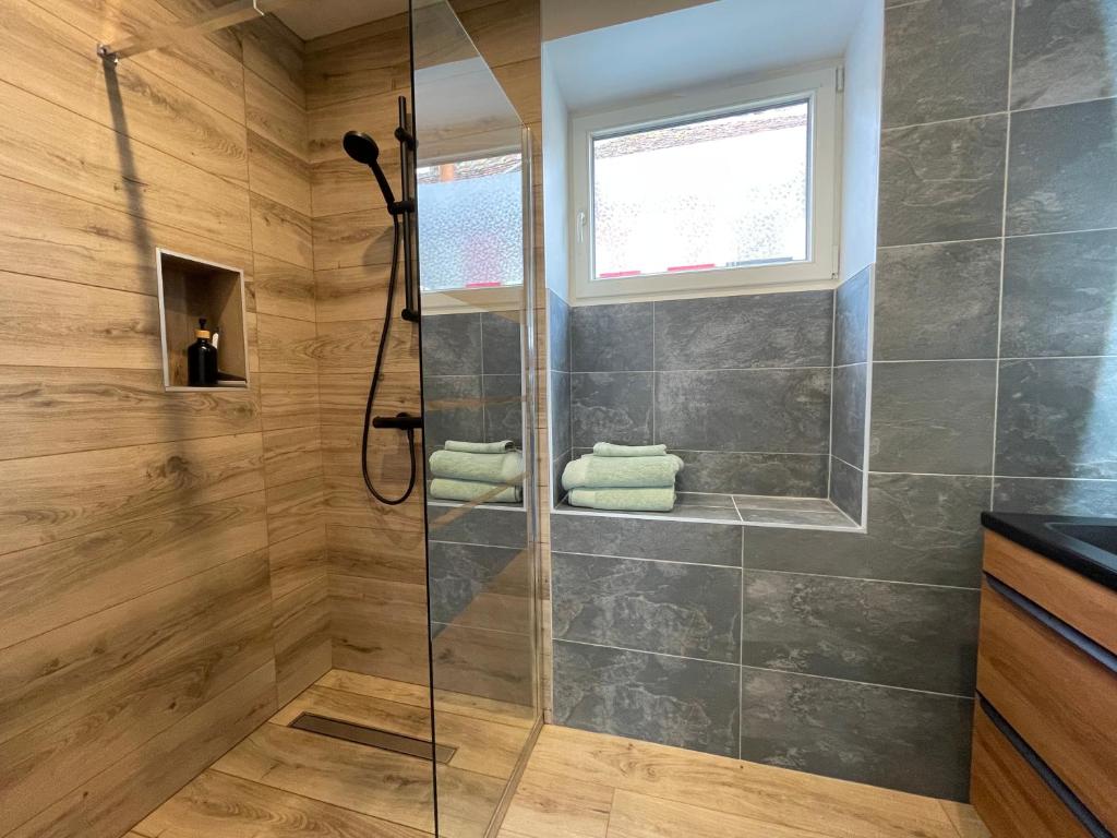 a bathroom with a shower with a glass door at Studio de la Poterie in Vermenton