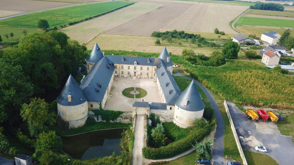 una vista aérea de un castillo en medio de un campo en 3 Gîtes avec piscine au Château de Charbogne 