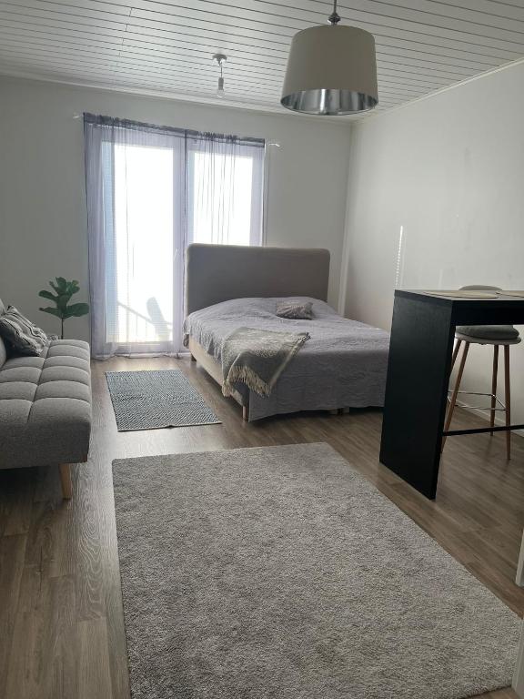 a bedroom with a bed and a couch and a table at Modern Apartment nearby Kerava in Kerava