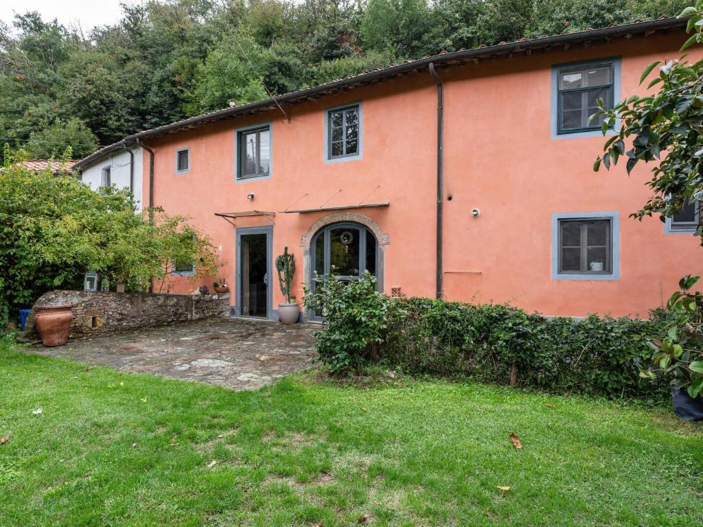 een oranje huis met een tuin ervoor bij Belvilla by OYO Holiday Home in Molina di Quosa in Pugnano