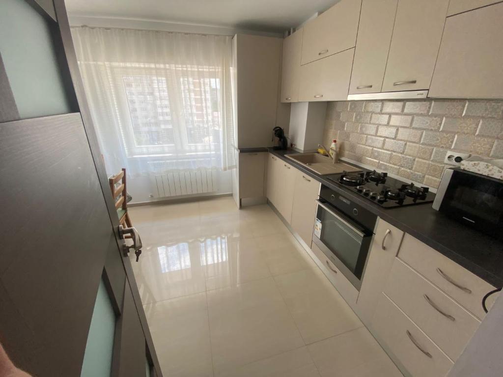 a kitchen with white cabinets and a stove top oven at Apartament Central Suceava in Suceava