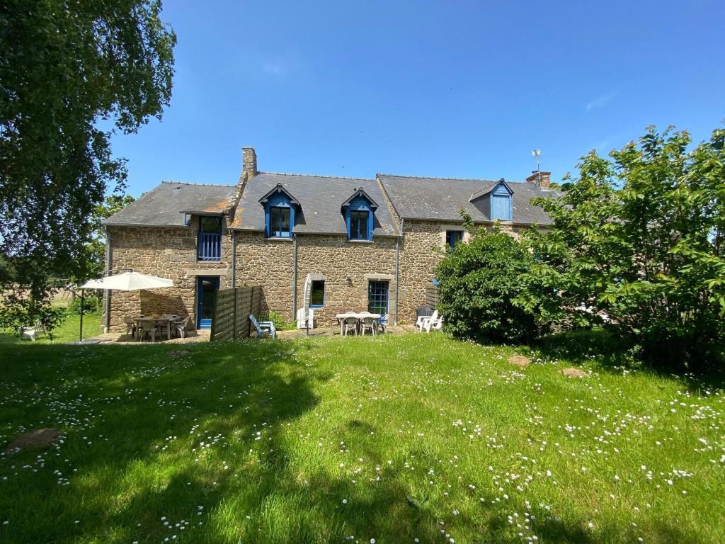 a large brick house with a grassy yard at Terraced house St Meloir des Ondes in Le Bouillon
