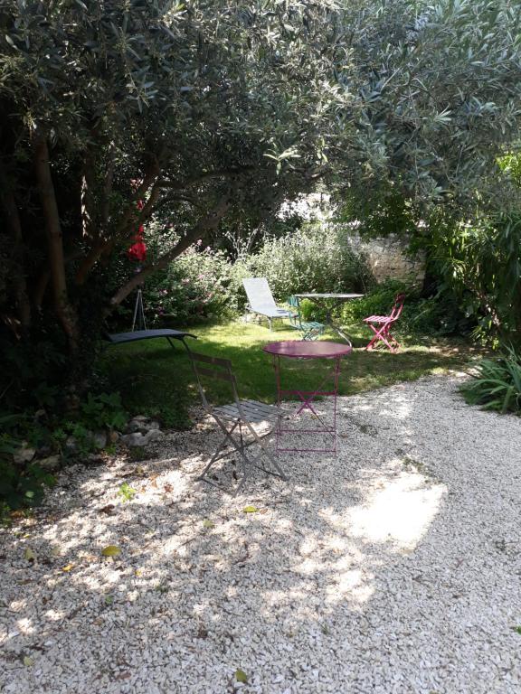uma mesa e duas cadeiras sentadas num quintal em La maison du jardin em Rustrel