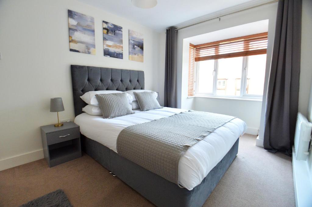 ein Schlafzimmer mit einem großen Bett und einem Fenster in der Unterkunft Luxury 2 BR Fully Furnished Flat in Crawley - 2 FREE Parking Spaces in Crawley