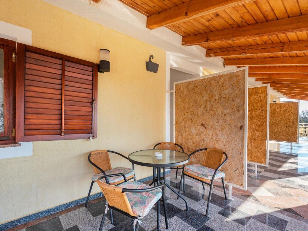 een patio met een tafel en stoelen in een kamer bij Beautiful Apartment in Jasenice near Sea in Jasenice