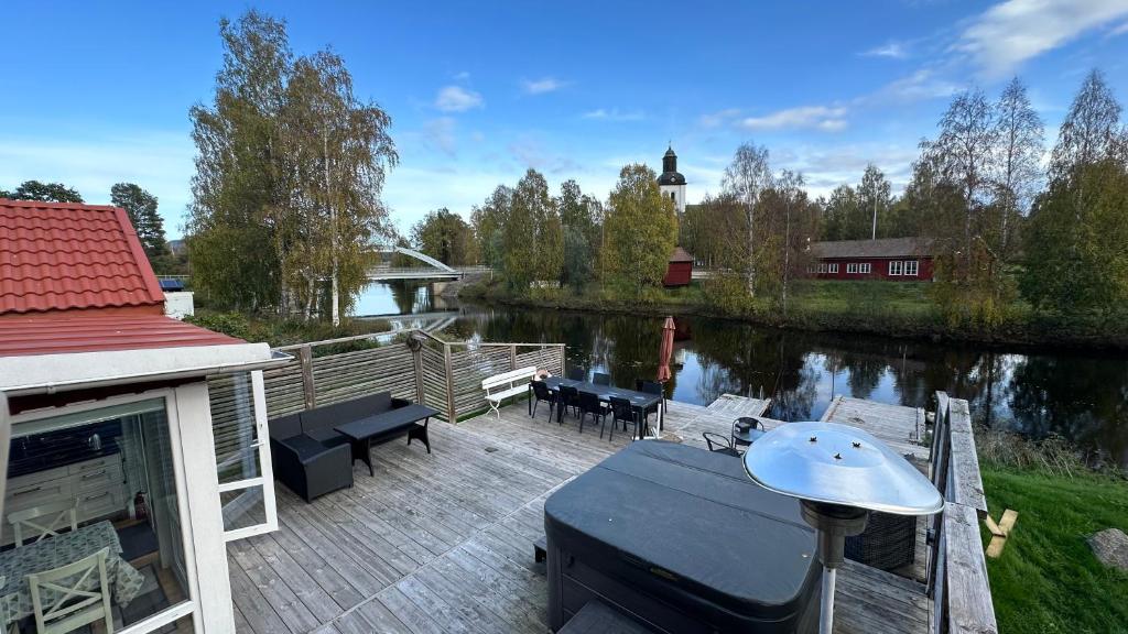 una terraza con mesa, sillas y un río en Strandvägen 4, en Järvsö