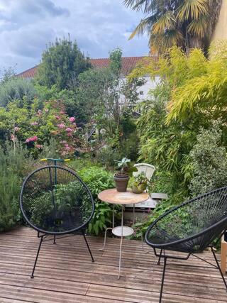 two chairs and a table on a wooden deck at Maison piscine centre historique de Romainville in Romainville