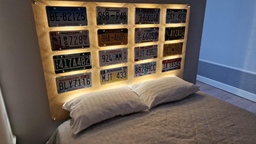 a bedroom with a bed with a wall of license plates at Przytulna Kawalerka w Kamienicy in Olsztyn