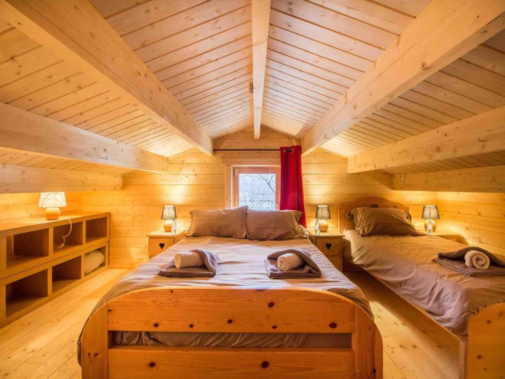a bedroom with two beds in a log cabin at Nordic Lodge in Peisey-Nancroix