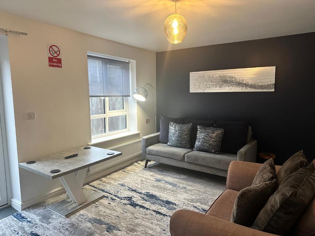 a living room with a couch and a table at Barber House, Hoyland in Hoyland Nether