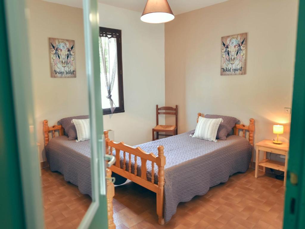 1 dormitorio con 2 camas y ventana en Village de gites Le Frigoulet, en Balazuc