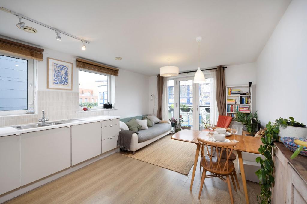 a kitchen and living room with a table and a couch at Lovely one bedroom apartment in Elephant Castle in London