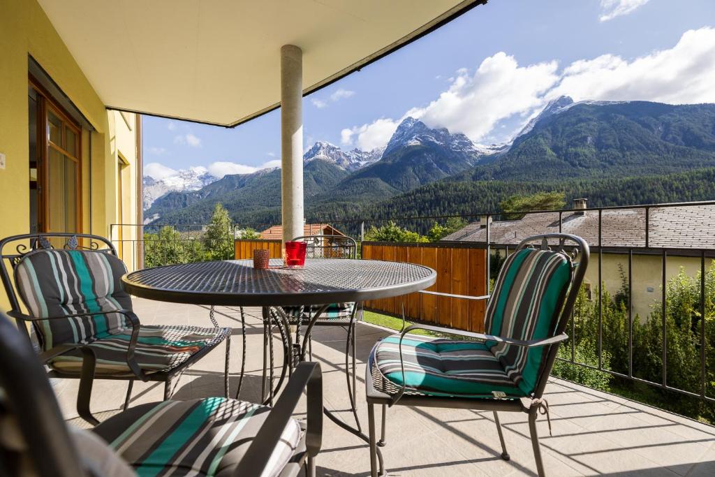 a patio with a table and chairs and mountains at Trü-Sura Nr. 7 in Scuol