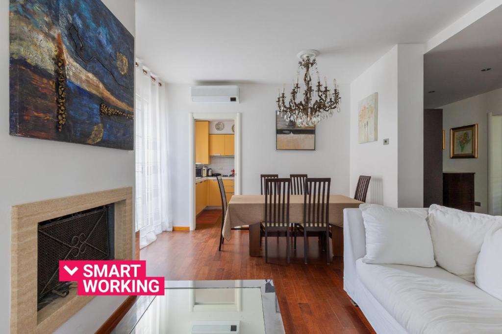 ein Wohnzimmer mit einem weißen Sofa und einem Tisch in der Unterkunft Zola Predosa Apartment by Wonderful Italy in Zola Predosa