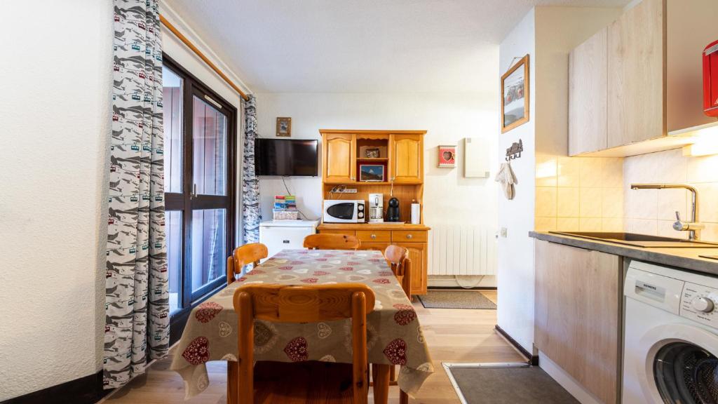 a small kitchen with a table and a sink at Grande Neige 23 - Appt pied des pistes 4 pers in Morillon