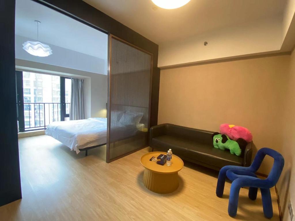 a bedroom with a bed and a couch and a chair at Manriver Executive Apartments in Guangzhou