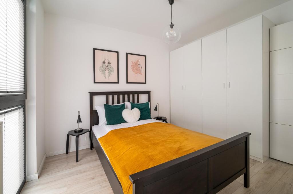1 dormitorio con 1 cama grande con almohadas verdes en Royal Wilanów Comfort Apartment, en Varsovia