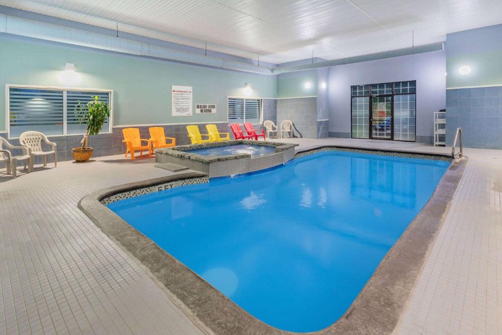 a large pool with blue water in a hotel room at Super 8 by Wyndham Cornwall ON in Cornwall