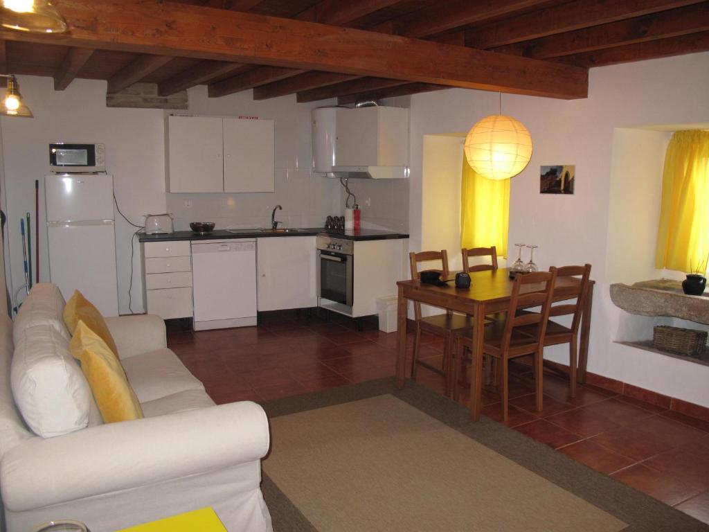 a kitchen and living room with a couch and a table at Casa do Castelo - Coroa in Castelo de Vide
