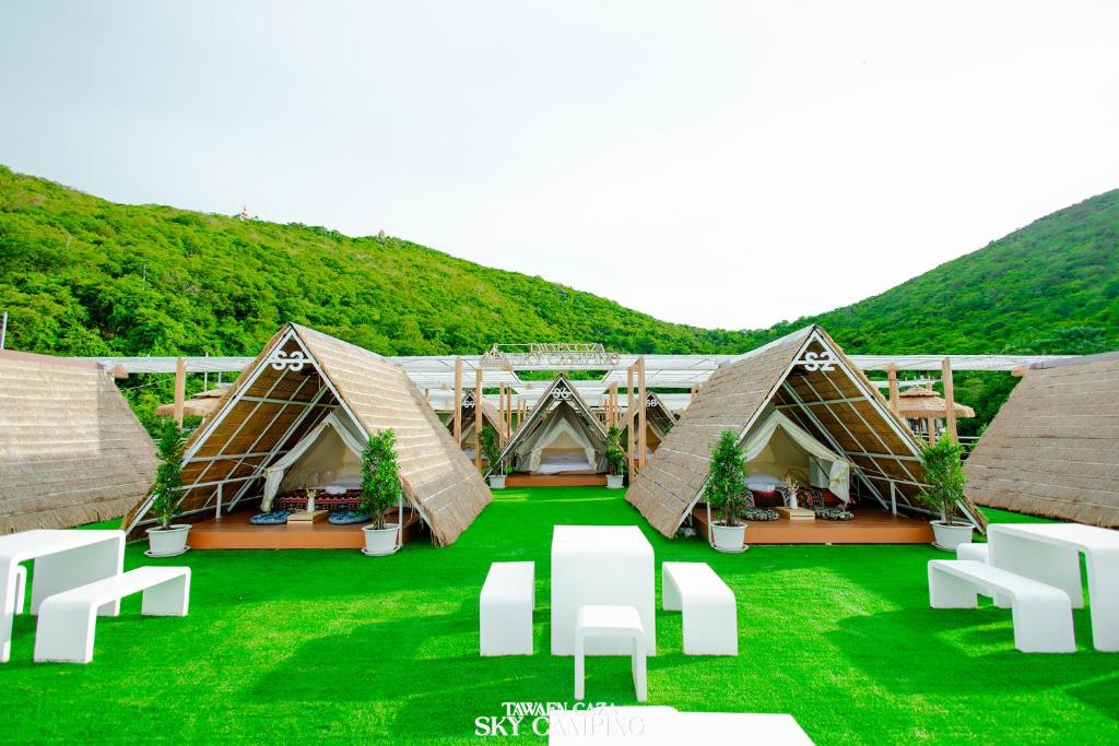 Un grupo de tiendas de campaña en un campo verde con césped. en Tawaen Caza Sky Camping, en Koh Larn