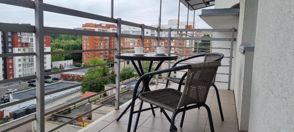 un tavolo e sedie su un balcone con vista sulla città di Затишна квартира з виглядом на парк a Ternopilʼ