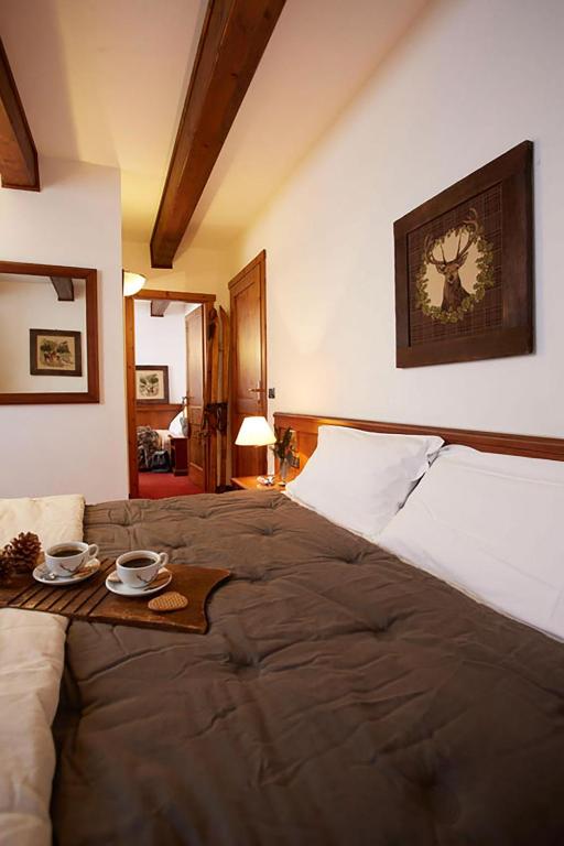 a bedroom with a large bed with a tray on it at Hotel Dei Camosci in Courmayeur