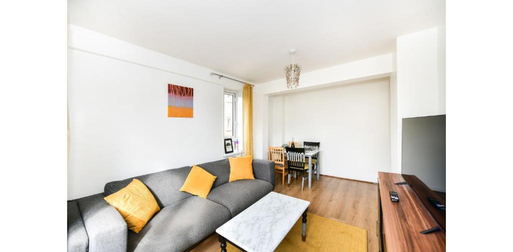 uma sala de estar com um sofá e uma mesa em Entire Two Bedroom Flat in the heart of Greater London em Londres