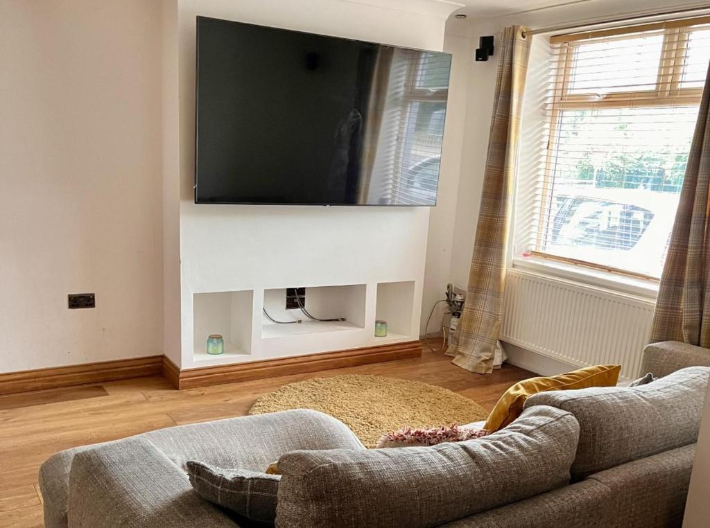 a living room with a couch and a flat screen tv at Modern Newly Renovated 3 Story House in Ebbw Vale in Ebbw Vale