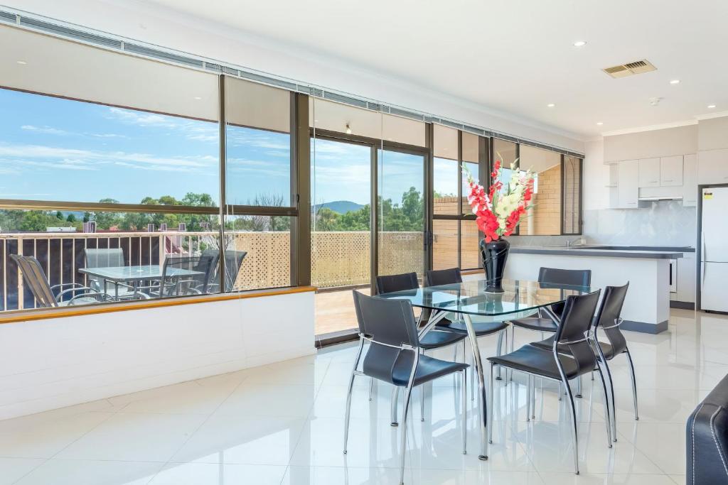 a kitchen and dining room with a glass table and chairs at Tuggeranong Short Stay #06C - Sleeps 6 in Canberra