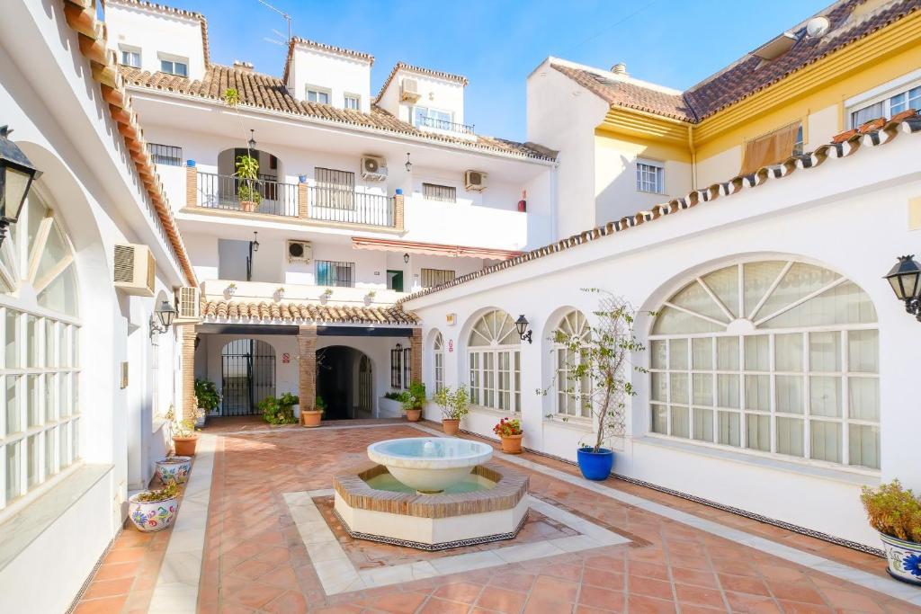 a courtyard with a fountain in the middle of a building at Patio Andaluz a 100 metros de la playa in Fuengirola