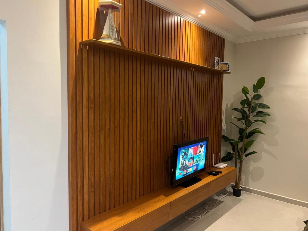 een tv aan een houten muur in een kamer bij Casa da mãe Aparecida. in Pindamonhangaba