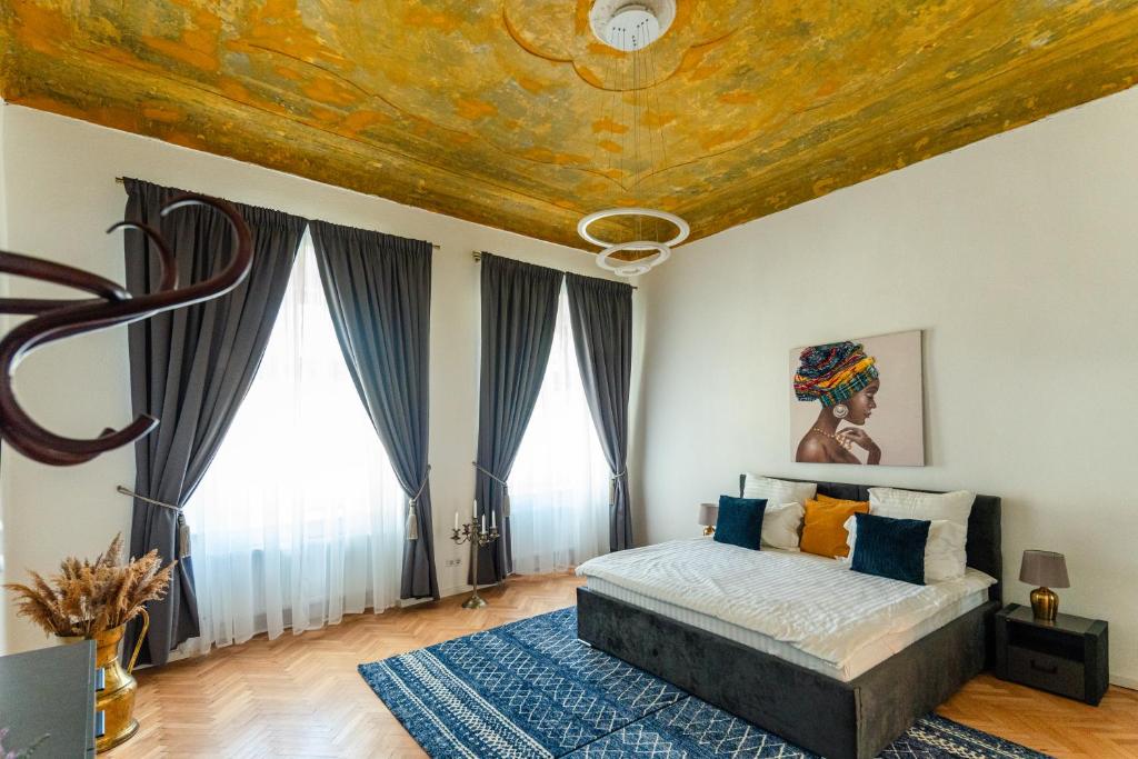 a bedroom with a bed with a gold ceiling at Schiller Rooms in Sibiu
