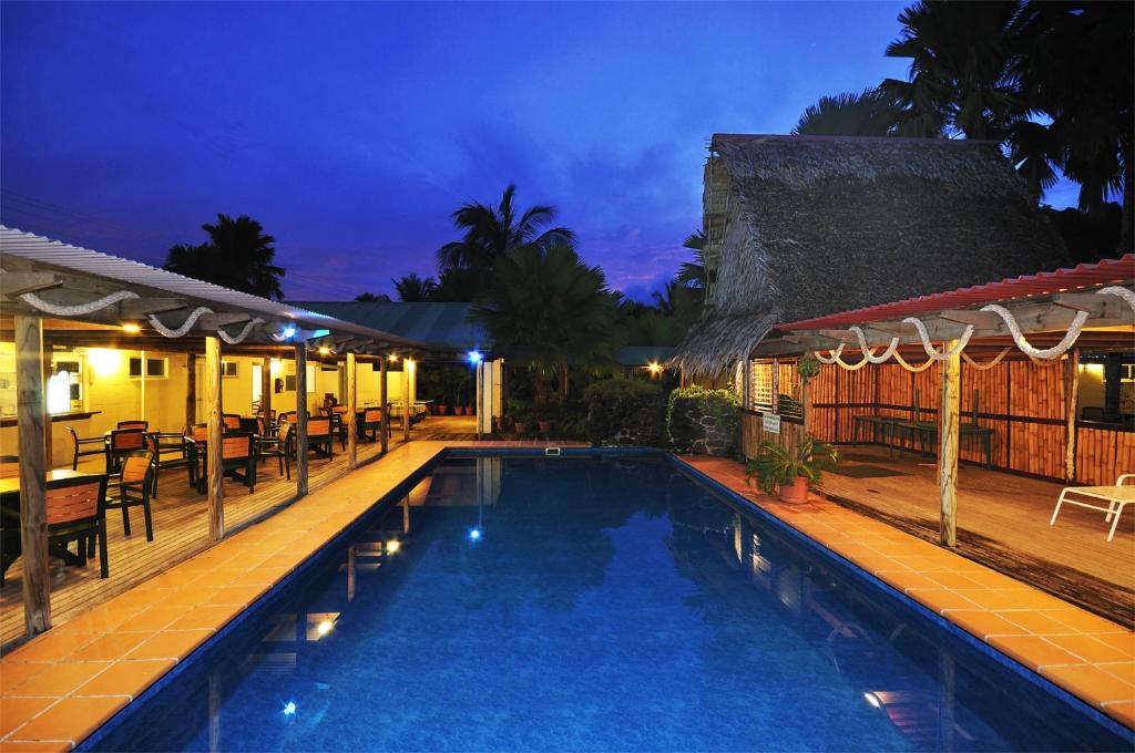 a swimming pool in front of a resort at night at Kosrae Nautilus Resort in Yepan