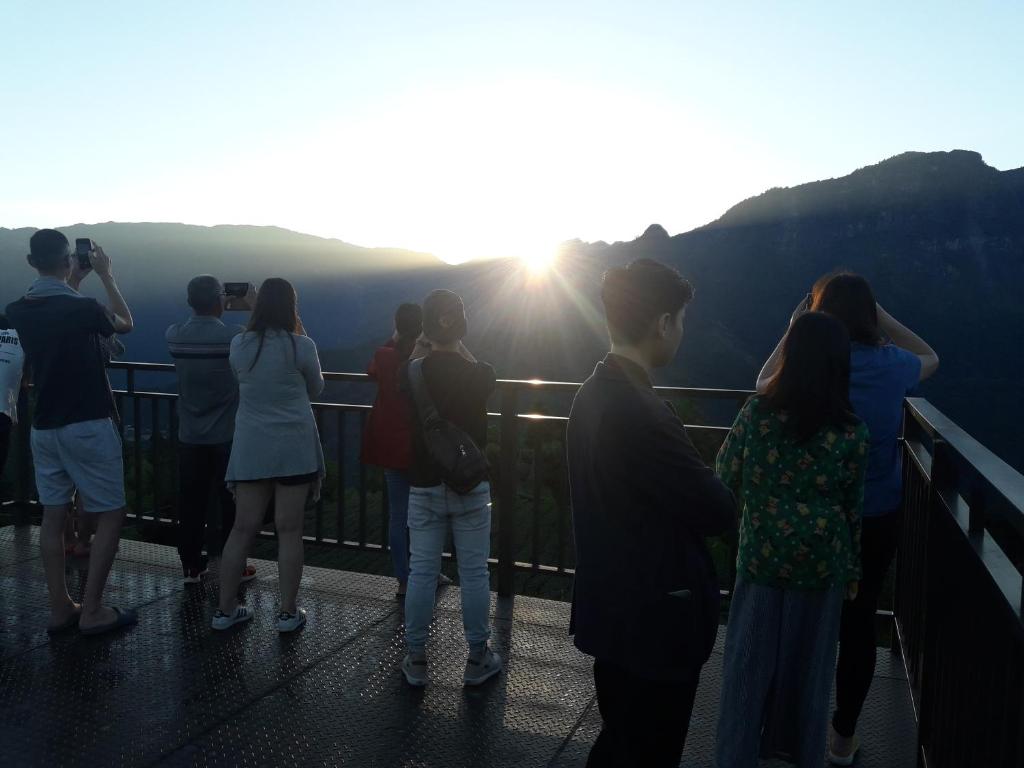 a group of people standing on the edge of a viewing deck at Alishan Shanyunhua B&B Homestay in Meishan
