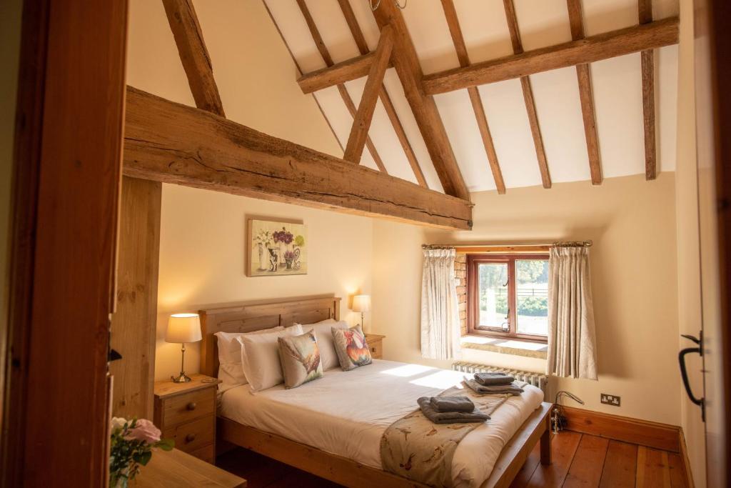 sypialnia z łóżkiem w pokoju z drewnianym sufitem w obiekcie The Threshing Barn w mieście Woodhall Spa