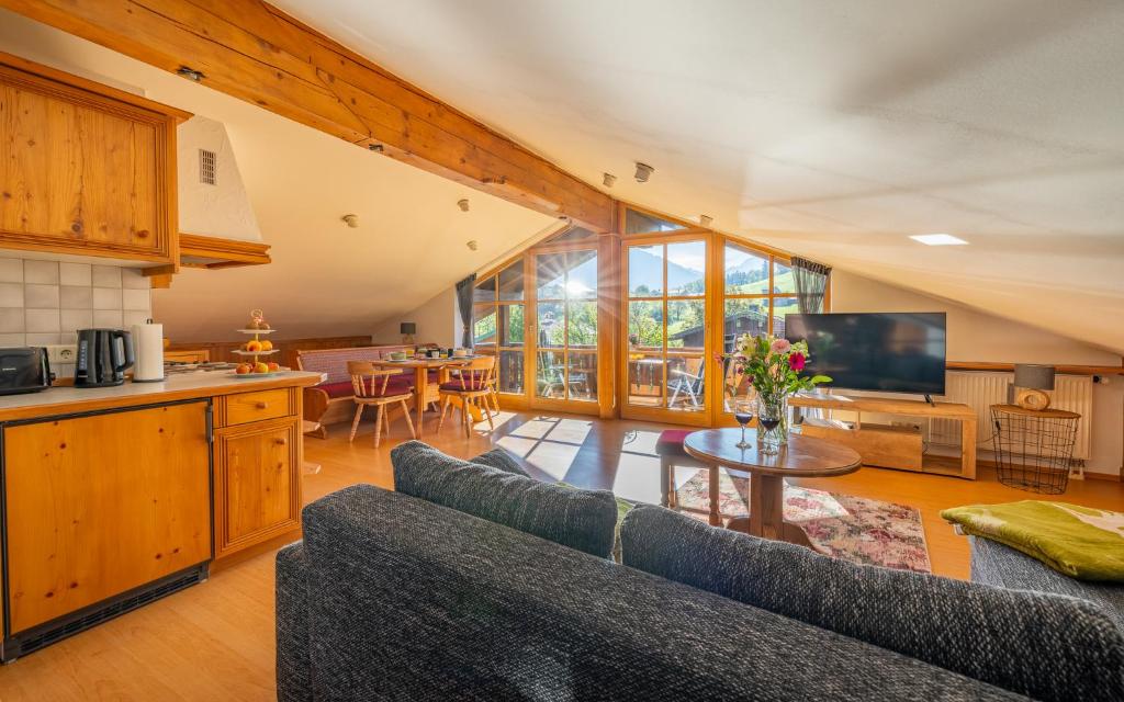 a living room with a couch and a table in a kitchen at Ferienwohnung Rauschbergblick in Ruhpolding