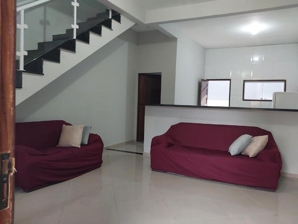 ein Wohnzimmer mit einem roten Sofa und einer Treppe in der Unterkunft Casa Familiar in Paraty