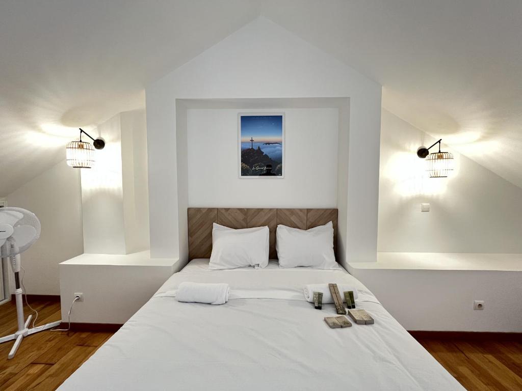 - une chambre dotée d'un lit blanc avec deux chaussures dans l'établissement Alexandrin, superbe appt avec varangue et vue mer pour 3 personnes, à Saint-Gilles les Bains